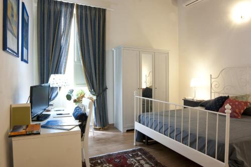 a bedroom with a bed and a desk with a computer at La Dimora Di Odisseo in Trapani
