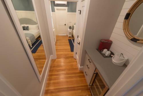 a hallway leading to a bedroom with a bed and a mirror at Paws on Pelham in Newport