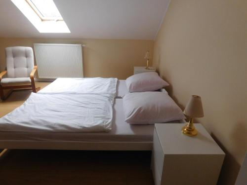 sypialnia z łóżkiem z białą pościelą i poduszkami w obiekcie Pokoje gościnne Barka w Wadowicach