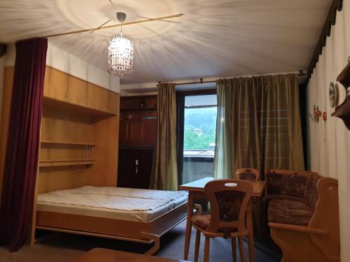 a bedroom with a bed and a desk and a window at Haus Anderl in Maria Alm am Steinernen Meer
