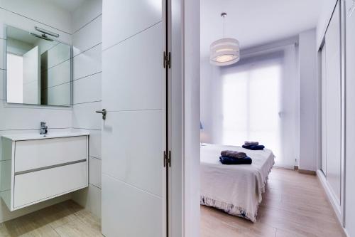 a white room with a bed and a mirror at Apartamento Pinada Beach- La Mata in La Mata