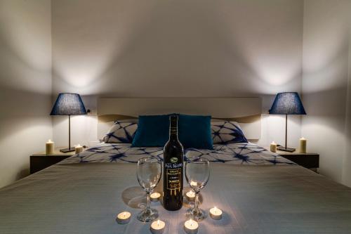 a bottle of wine sitting on a bed with two glasses at Apartamento Pinada Beach- La Mata in La Mata