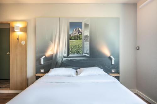 a bedroom with a large bed and a window at B&B HOTEL Saint Jean De Maurienne in Sainte-Marie-de-Cuines