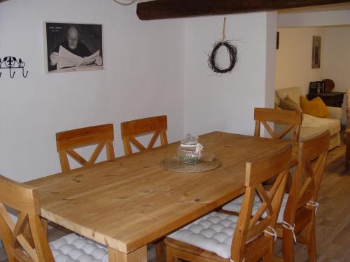 una mesa de comedor de madera y sillas en una habitación en Ferienhaus Kaline en Grebenhain
