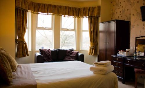 a bedroom with a bed and a large window at Beverley Hotel in Walsall