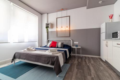 1 dormitorio con cama y ventana grande en Apartamentos Navío en Valencia