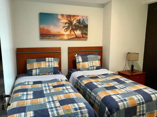 マサトランにあるPeninsula Mazatlanのベッドルーム1室(ベッド2台付)が備わります。壁には絵画が飾られています。