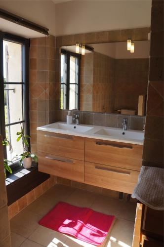 a bathroom with two sinks and a large mirror at Le Mas Nathael in Vaison-la-Romaine