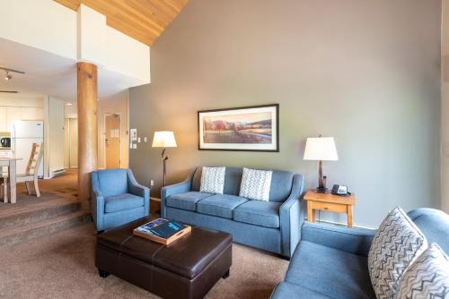 a living room with a blue couch and chairs at The Ironwood on Blueberry Hill in Whistler