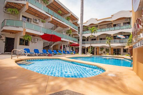 a swimming pool in front of a building at Hotel & Suites Mar y Sol Las Palmas in Rincon de Guayabitos