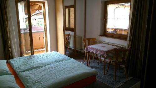 une chambre avec un lit, une table et une fenêtre dans l'établissement Haus Schiestl, à Zell am Ziller