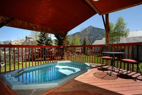 a swimming pool with a table and two chairs at Cristiana Guesthaus in Crested Butte