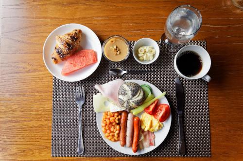 a table with two plates of food and a cup of coffee at Hotel Max Inn in Bratislava