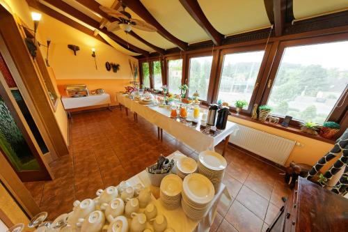 a large room with a long table with dishes at Hotel Max Inn in Bratislava