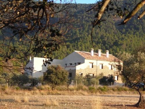 a large white house in the middle of a field at Casa Rural Cortijo La Ajedrea in Siles