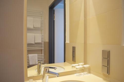 a bathroom with a sink and a mirror at Augusten Hotel München in Munich