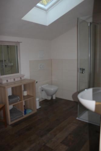 a bathroom with a toilet and a sink and a tub at Ferienwohnung Goldgrund Gartenblick in Meißen