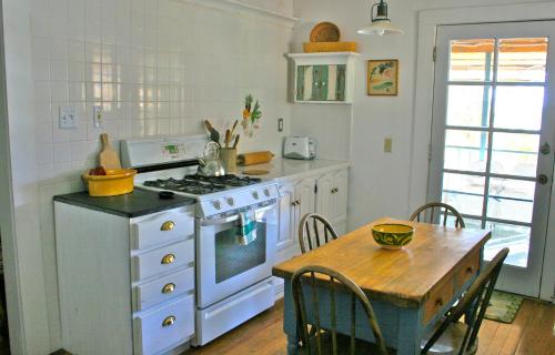a kitchen with a stove and a wooden table at Old Pioneer Garden Country Inn in Unionville