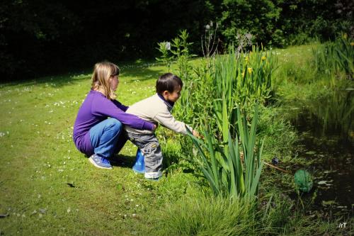 a woman and a child looking at a plant at Stutteri Skandihest Apartments in Billund