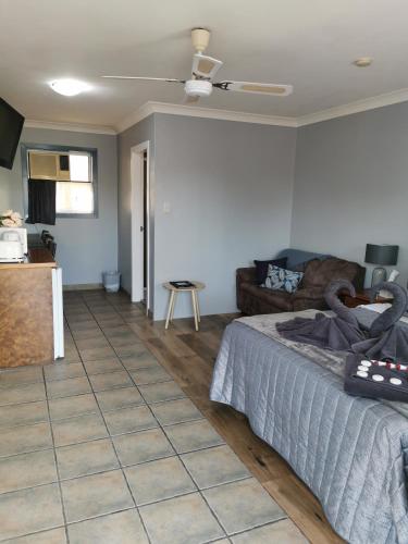 a living room with a bed and a couch at Limassol Motel in Gold Coast