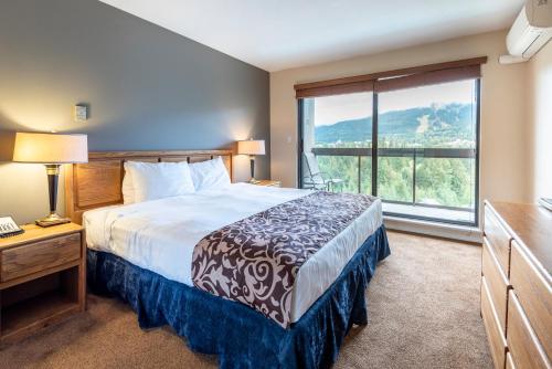 a hotel room with a bed and a large window at The Ironwood on Blueberry Hill in Whistler