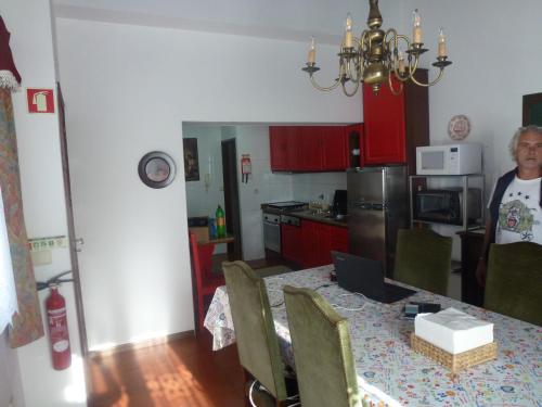 a man standing in a kitchen with a table with a laptop at Home of pilgrims d`Apúlia in Apúlia