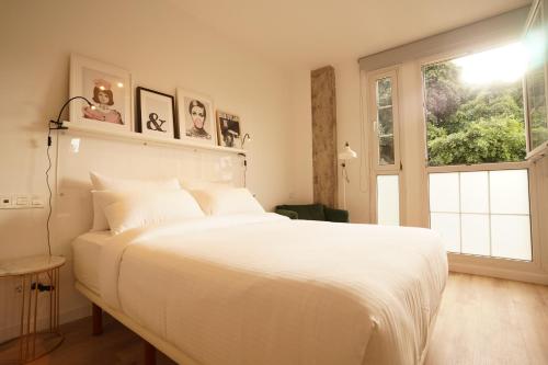 Un dormitorio con una gran cama blanca y una ventana en THE STAY Las Palmas VV, en Las Palmas de Gran Canaria