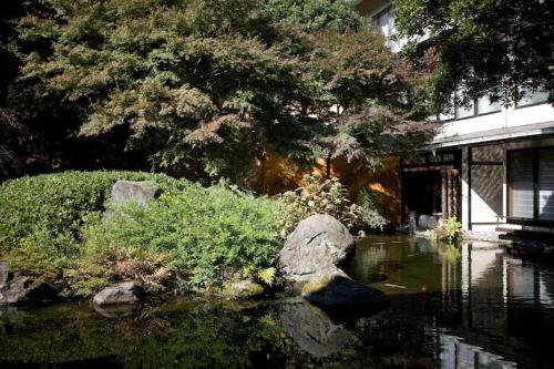 a garden with rocks and trees and a pond at Oku Yugawara Tsubaki in Yugawara