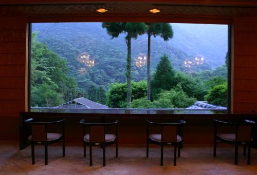 a room with a large window with a table and chairs at Oku Yugawara Tsubaki in Yugawara