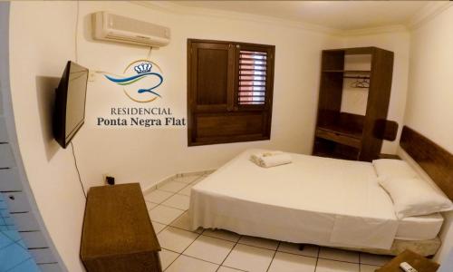 a hotel room with a bed and a sign on the wall at Residencial Ponta Negra Flat in Natal