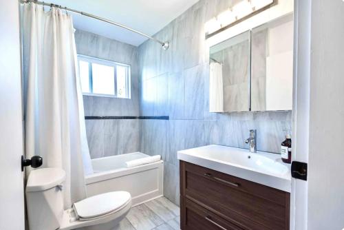 a white bathroom with a sink and a toilet at LOVELY HOME 10 MINUTES TO DOWNTOWN !!! in Victoria