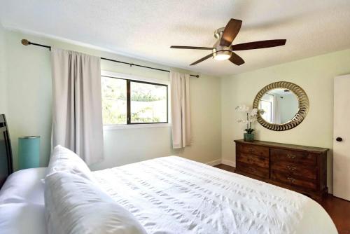 a bedroom with a white bed and a ceiling fan at LOVELY HOME 10 MINUTES TO DOWNTOWN !!! in Victoria