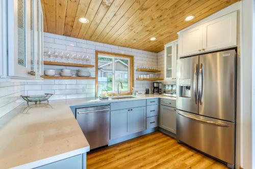 a kitchen with a stainless steel refrigerator and wooden ceilings at Eagle's Nest Retreat in Maple Grove Beach