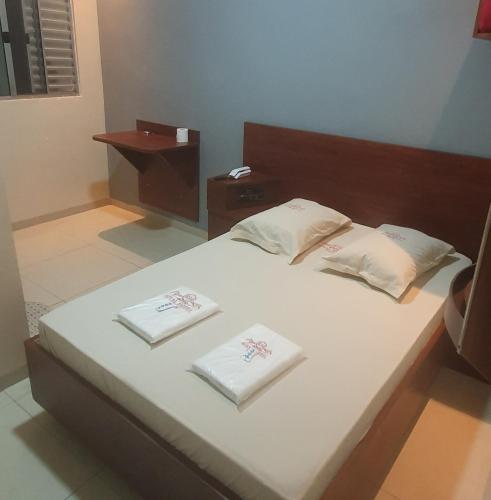a bedroom with a bed with two towels on it at hotel royal brás in São Paulo