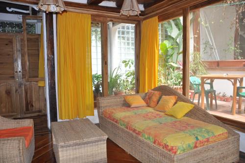 a living room with a couch and some windows at Hostería Mandála in Puerto López