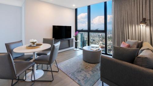 墨爾本的住宿－Avani Melbourne Central Residences，客厅配有沙发和桌椅