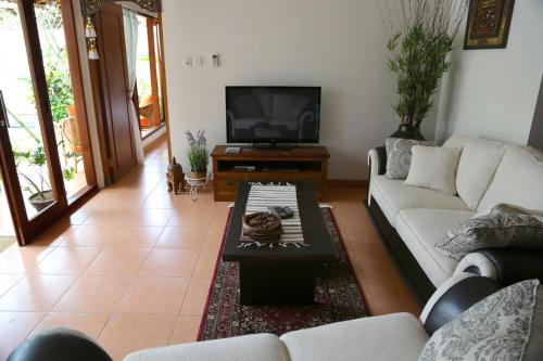 a living room with a couch and a tv at Villa Chinta 1 in Sanur