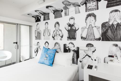 a bedroom with a bed and a wall with pictures at Majestic Minima Hotel in Adelaide