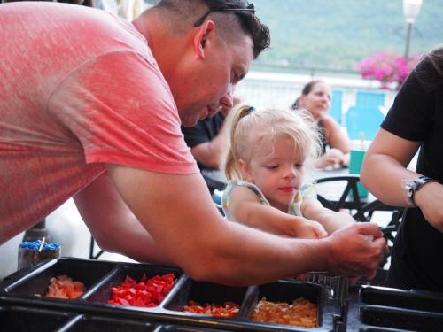 a man holding a little girl in front of food at The Lake Motel in Lake George