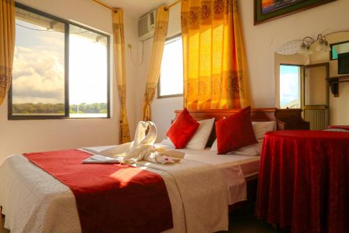 a bedroom with a bed with red and yellow curtains at Hostal Sir Francis Drake in Puerto Ayora