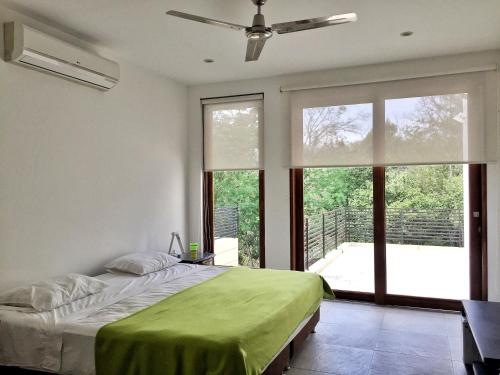 a bedroom with a bed and a large window at Lagos del Peñon: Casa 10 - Puerto Madero in Girardot