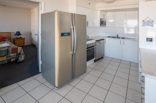 a kitchen with a large stainless steel refrigerator at Centrepoint Apartments Caloundra in Caloundra