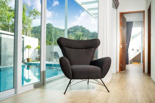a black chair in a room with a pool at Villa Kamala close to the beach in Kamala Beach