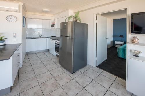 a kitchen with a stainless steel refrigerator at Centrepoint Apartments Caloundra in Caloundra