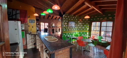 Hostel Ruca Potu في ميندوزا: مطبخ مع كراسي خضراء وكاونتر في الغرفة