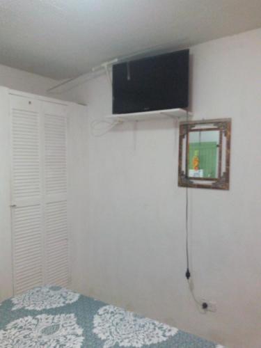 a bedroom with a bed and a television on the wall at Posada Green Sea San Luis pesos with breakfast included starting in March in Cueva de Morgan