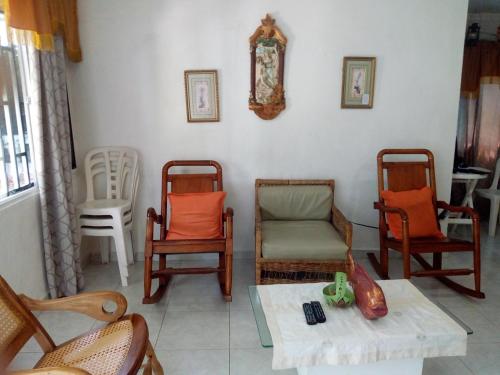 a living room with chairs and a table and a table at Posada Green Sea San Luis pesos with breakfast included starting in March in Cueva de Morgan
