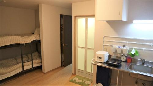 Cette petite chambre comprend une cuisine et des lits superposés. dans l'établissement Sadie's Home, à Waizumi