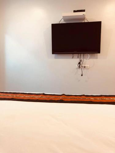 a flat screen tv hanging on a white wall at Chiangmun Boutique in Chiang Mai