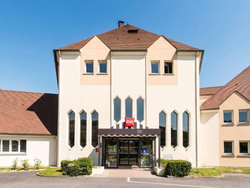 a large white building with a red sign on it at Ibis Château-Thierry in Essômes-sur-Marne